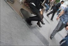 Wearing all black on a wooden chair in the market square